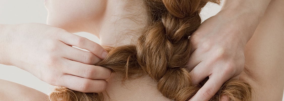 A woman platting her hair